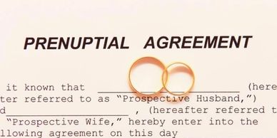 Two wedding rings on a prenuptial agreement.