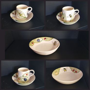 group of cups and saucers with painted bugs and leaves on them