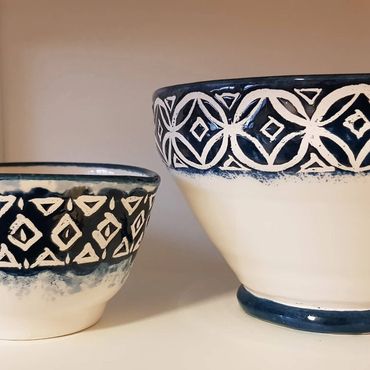 Two bowls with dark blue bands that have had wax resist pattern