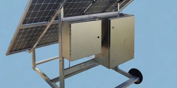 Mobile solar panel system with control boxes mounted on a wheeled frame.
