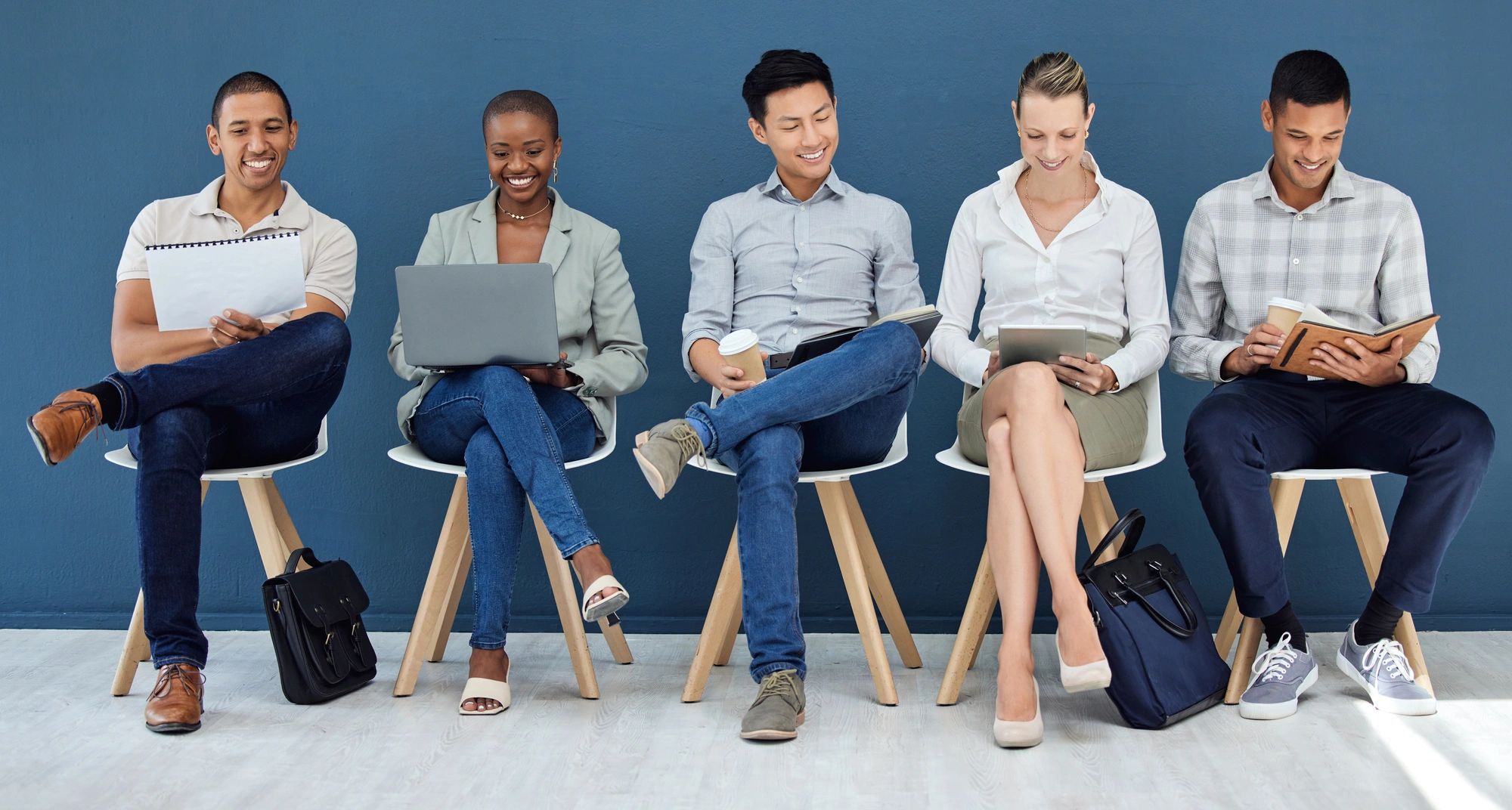 Group of business people sitting in white chairs.