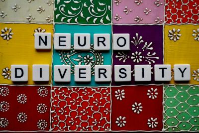 Tiles spelling "Neurodiversity" on colorful patterned background.