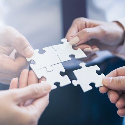 A group of business people assembling a jigsaw puzzle. The concept of cooperation
