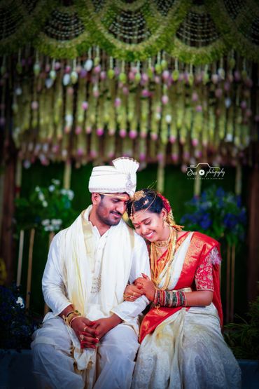 Traditional Indian couple in wedding attire sharing a joyful moment.