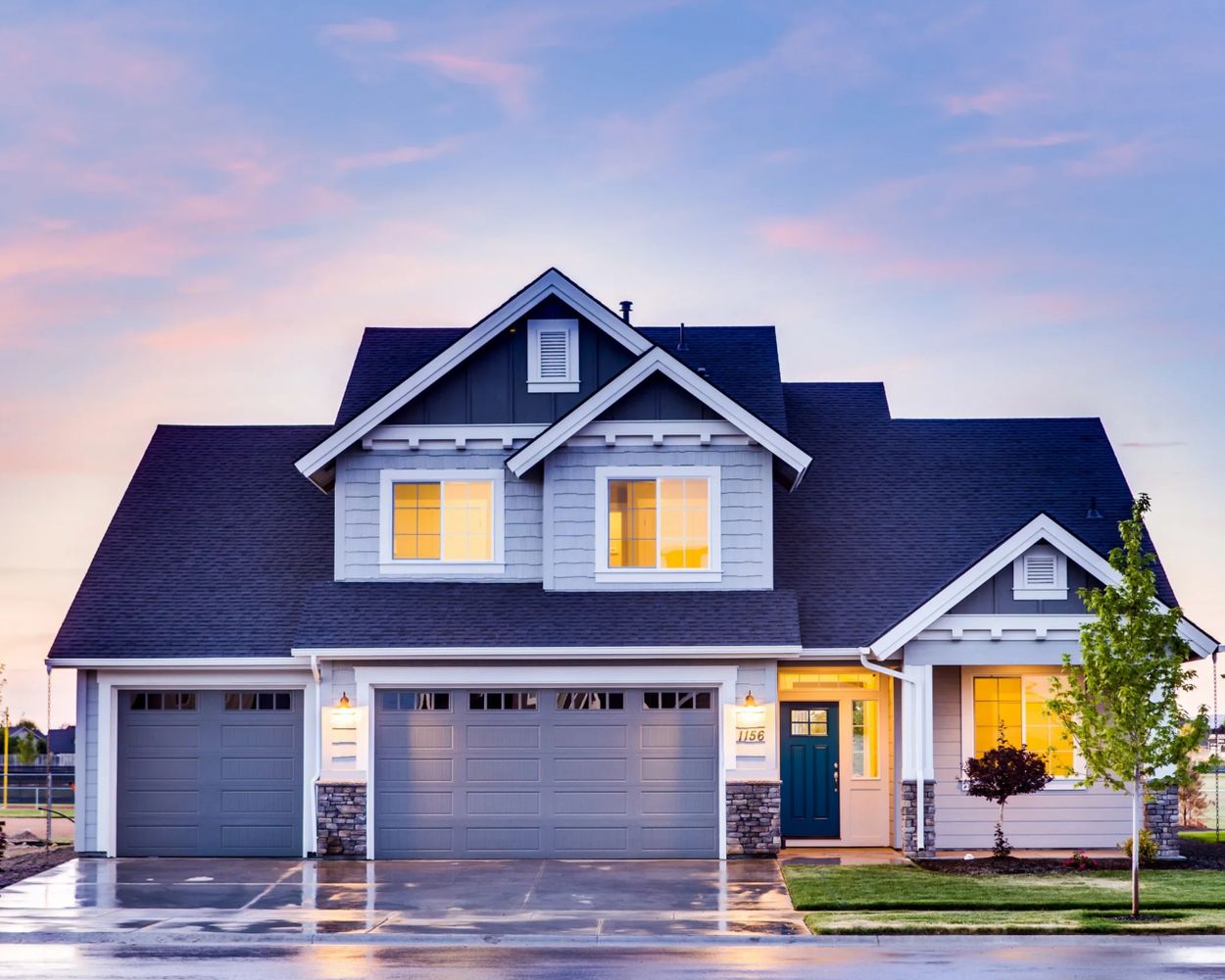 Modern suburban house with lit windows at dusk.