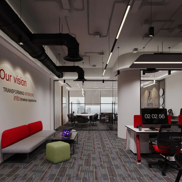 Modern office with red and gray seating, patterned carpet, and glass-walled conference room.