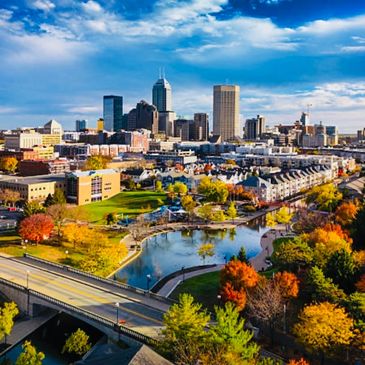 City skyline with autumn trees and a river.