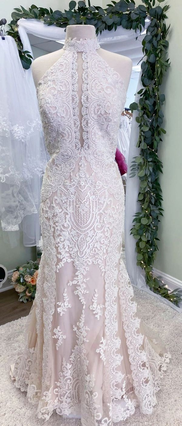 Elegant lace wedding dress with intricate patterns and a high neckline.