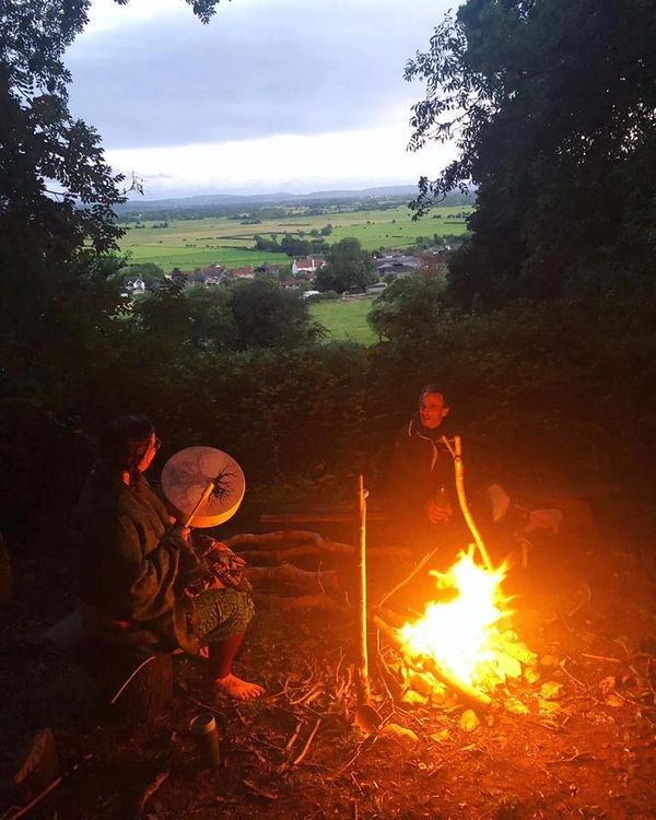 Nature therapy. Ecotherapy. Sitting around fire, connecting to nature. Drumming.
