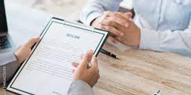 A picture of the Human Resources department reviewing someone's Resume at a job interview.