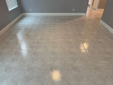 Shiny tiled floor reflecting light in an empty room.