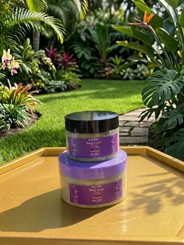 Two jars of body scrub with purple labels on a golden surface outdoors.