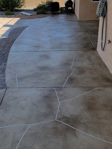 Backyard patio with stamped concrete and mountain view.