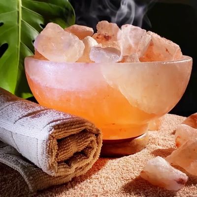Steaming bowl with Himalayan salt chunks and rolled towel.