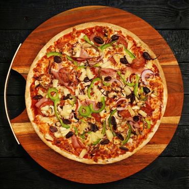 A colorful pizza with various toppings on a wooden board.