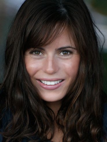 Woman with brown hair smiling.