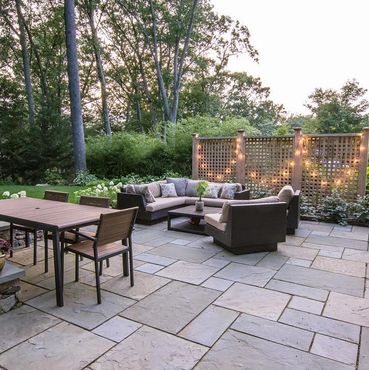 Bluestone patio, fieldstone steps and wall, cedar fencing and landscape lighting.