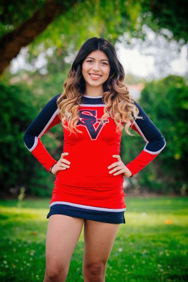 Smiling young cheerleader in red and black uniform.