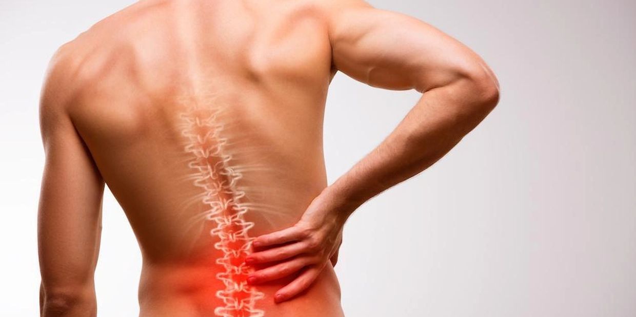 Man holding his lower back in pain, highlighting the spine with red inflammation.