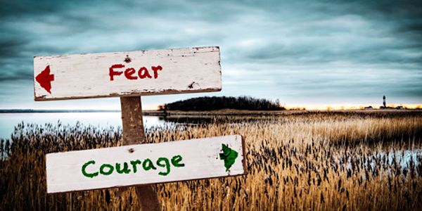 A sign pointing in the direction of fear or courage as a choice using Hypnosis treatments. 