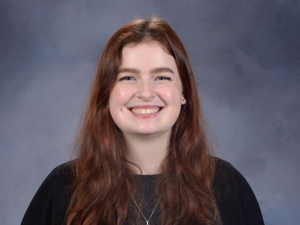 Smiling young woman with long brown hair.