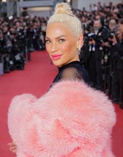 ingrid blonde woman with pink fur coat on the red carpet with paparazzi