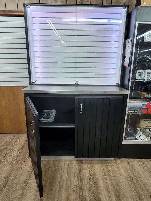 Display cabinet with locking glass doors and storage base. LED backlight