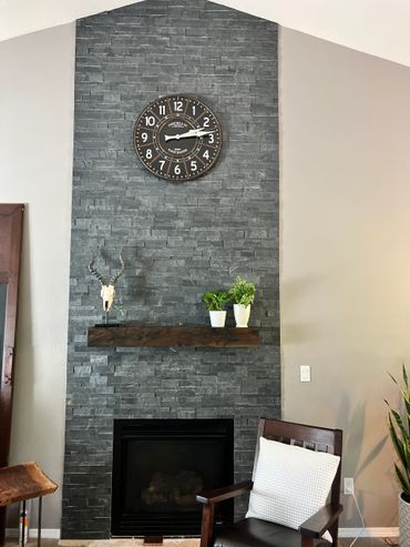 Rustic fireplace mantel and clock on a stone fireplace 
