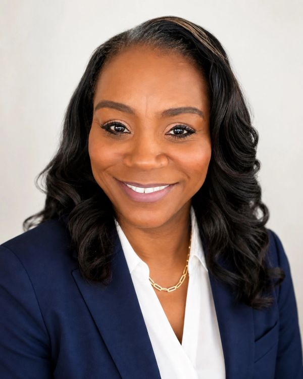 Professional woman in a navy blazer and white shirt.