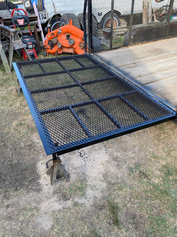 Metal mesh ramp attached to a trailer for loading and unloading.