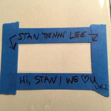 Blue tape frame with a tribute to Stan Lee written in black marker.