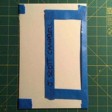 White board with blue painter's tape and name written on it.