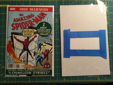 Classic Amazing Spider-Man comic with a taped white backing on a cutting mat.