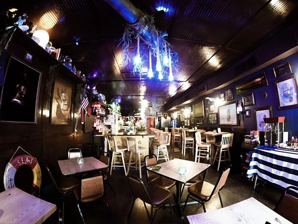 Cozy nautical-themed bar with wooden furniture and pirate decor.