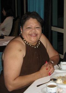 Close up image of a lady in brown dress smiling at the camera