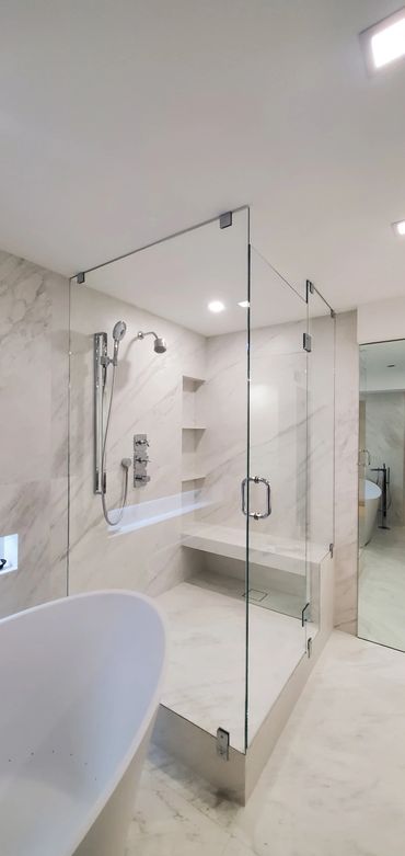 Modern bathroom with glass shower enclosure and freestanding tub.