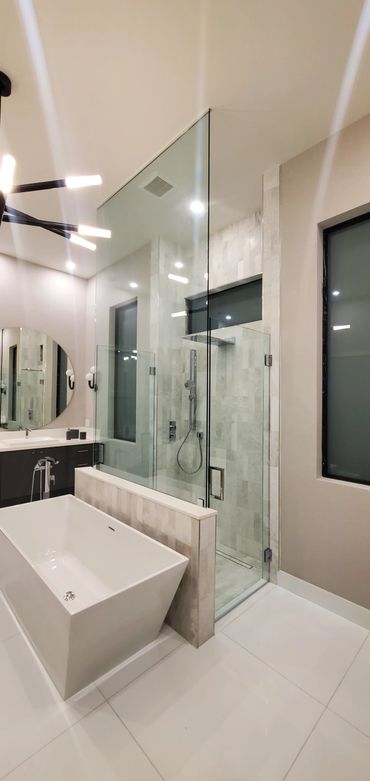 Modern bathroom with a freestanding tub, glass-enclosed shower, and minimalist design.