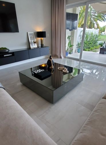 Modern living room with sleek black coffee table and neutral tones.