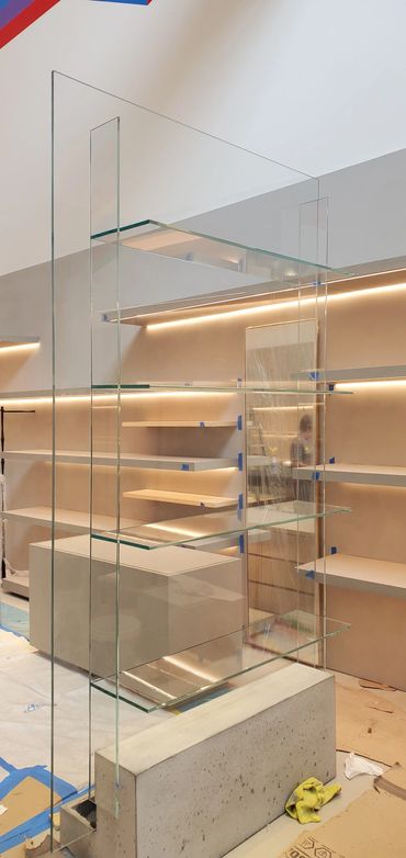 Modern glass shelves with concrete base in a minimalist interior under construction.