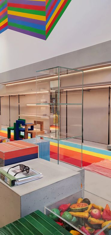 Modern art gallery space with colorful installations and glass displays.