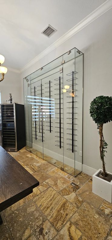 Modern glass wine rack with metal holders in a stylish room.