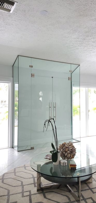 Modern glass enclosure in a bright living room with a stylish coffee table.