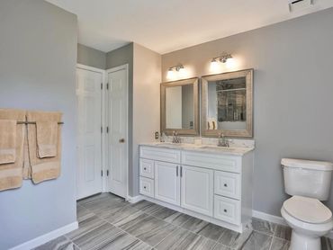 Porcelain tile in bathroom remodel with double sink vanity and granite countertop.
