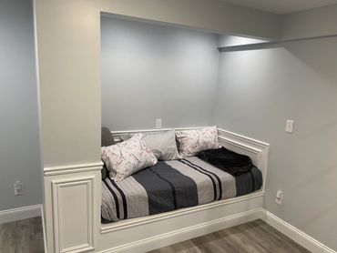 Basement reading nook (book nook) with mattress, lighting, and moulding.