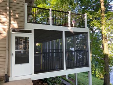 Covered deck with treated wood and screened in porch.
