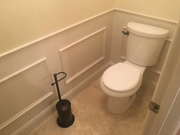 Water closet with custom chair rail moulding with travertine flooring tile