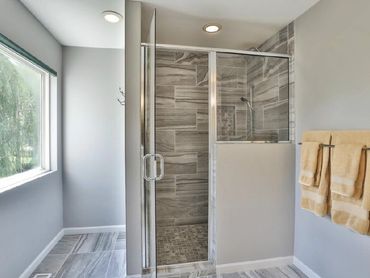 Walk in shower with recessed lighting and porcelain tile in master bathroom.