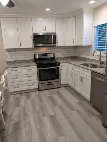 Soft Close cabinet with crown molding, vinyl plank flooring, and granite countertops.