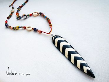 N821
Description: 
Long Zebra Pattern Bone Pendant in a long adjustable Necklace with a mix of Afric