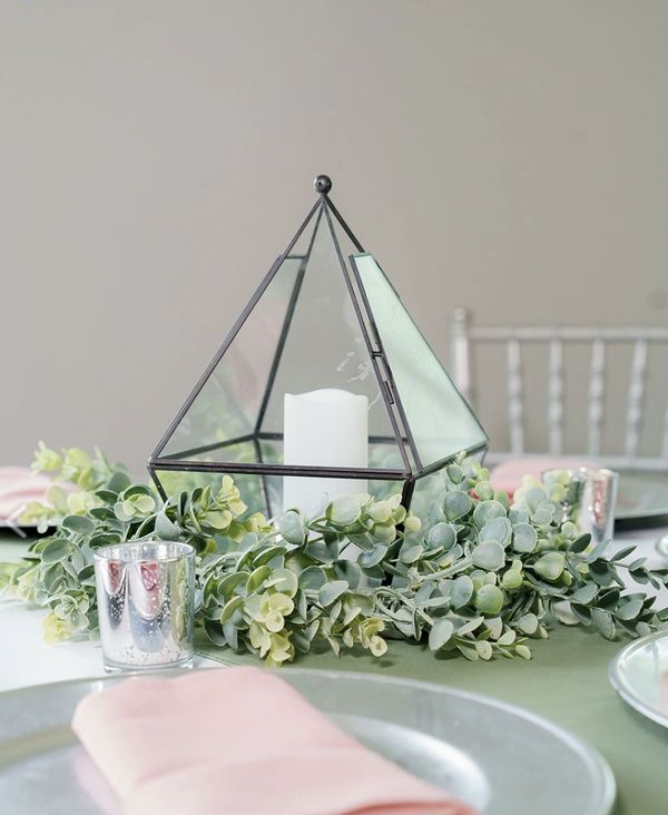 Black metal Pyramid candle centerpiece with greenery and silver votives